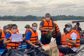 [Ảnh] Cận cảnh đội phản ứng nhanh dùng xuồng hơi trao quà tới hộ nghèo làng chài ven sông Hồng