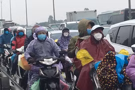 Người dân đội mưa trở lại thành phố sau kỳ nghỉ Tết Nhâm Dần