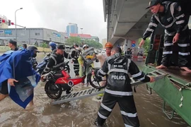 Công an Hà Nội dùng xe chuyên dụng đưa dân qua điểm ngập sâu