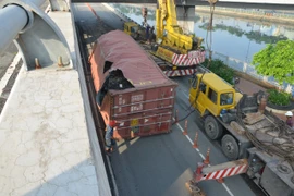 Thùng container rơi từ trên cầu xuống đất, rách bươm