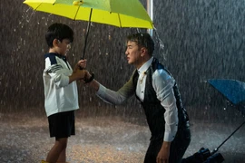 Hình ảnh Đàm Vĩnh Hưng và con trai Polo Huỳnh dắt tay nhau đi trong mưa 
