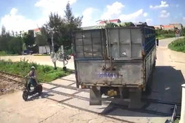 Xe tải cố tình húc bay gác chắn tàu đang hạ làm 1 người đi đường bị thương