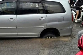 Ô tô Innova sụt "hố tử thần" giữa đường Nguyễn Chí Thanh do bục đường ống nước sạch