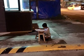 Nghị lực đáng khâm phục của cậu bé vô gia cư học bài bên lề đường