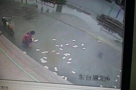 Người dân nhặt giúp tiền bị gió thổi bay tứ tán