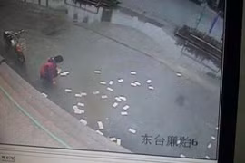 Người dân nhặt giúp tiền bị gió thổi bay tứ tán