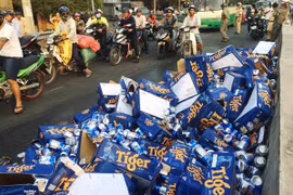 Người dân giúp tài xế thu dọn hàng trăm thùng bia đổ xuống đường