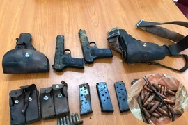 Một người dân giao nộp 2 khẩu súng K54 cùng nhiều đạn và hộp tiếp đạn