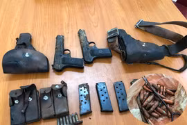 Một người dân giao nộp 2 khẩu súng K54 cùng nhiều đạn và hộp tiếp đạn