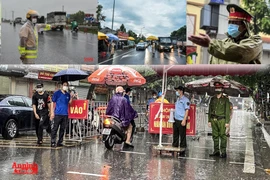 [ẢNH] Công an Hà Nội đội mưa lớn kiểm soát "ngoài chặt, trong chặt" để ngăn dịch bệnh