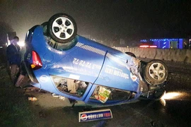 Xe taxi đâm vào dải phân cách rồi lật ngửa trên quốc lộ