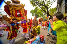 Không khí linh thiêng khi kiệu Thánh đi qua. Người dân chắp tay thành kính bái vọng, trong khi nhịp trống hội tiếp tục thúc giục bước chân dồn dập của các "phụ giá".