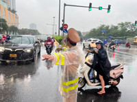 Hình ảnh Cảnh sát giao thông Hà Nội đội mưa lớn, phân luồng giúp nhân dân đi lại an toàn