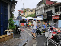 [Ảnh] Hàng chục CBCS đội mưa lớn, tiếp nhận hàng hóa cho nhân dân trong vùng phong tỏa Văn Miếu - Văn Chương