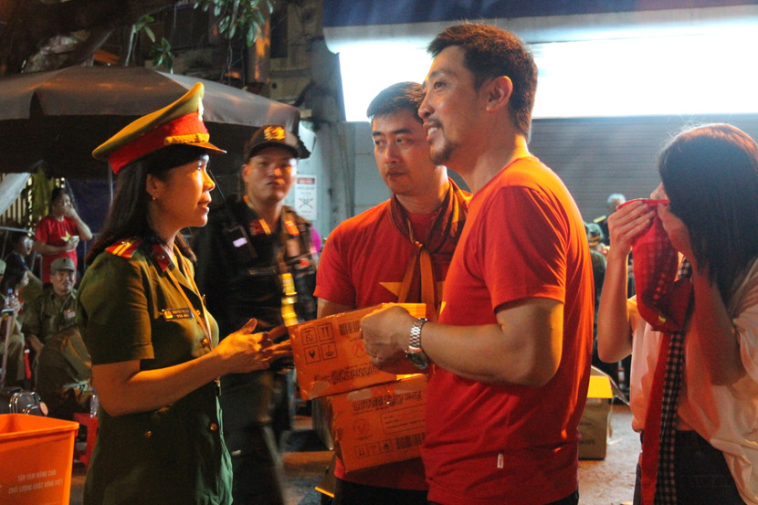 Nhóm nghệ sĩ hỗ trợ các cán bộ chiến sĩ Công an Phường Ô Chợ Dừa trao suất ăn khuya tới các cựu chiến binh, người có công và người cao tuổi tại khu vực ưu tiên được Phường bố trí