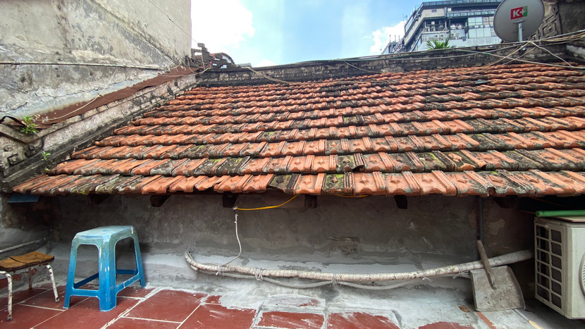 Phần mái ngói được xếp dốc, hai bên đầu rồng nối nhau bằng thành bê tông khắc hình dải hoa đăng Phần mái ngói được xếp dốc, hai bên đầu rồng nối nhau bằng thành bê tông khắc hình dải hoa đăng