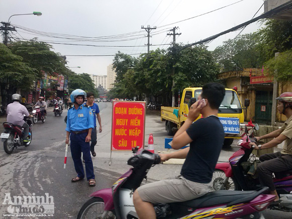 Giúp người dân qua đoạn đường ngập úng ảnh 2