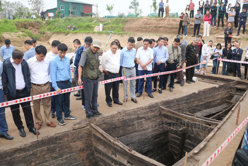 Các chuyên gia, nhà nghiên cứu khảo sát hiện trường khu vực đang tiến hành khai quật và nghiên cứu chiếc thuyền cổ (ảnh: Bắc Ninh online)