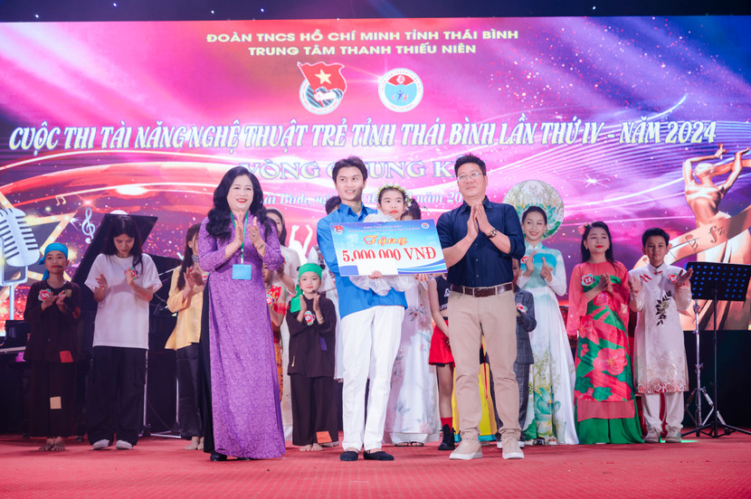 NSND Quốc Hưng cùng bà Vũ Thị Nga - Trưởng Ban tổ chức cuộc thi trao tặng các món quà đặc biệt để cổ vũ tài năng và niềm đam mê của thí sinh có nghị lực phi thường Phạm Thanh Bình.