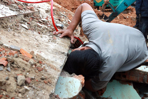 Người chồng xông vào hiện trường tìm kiếm vợ con. Ảnh: Xuân Ngọc