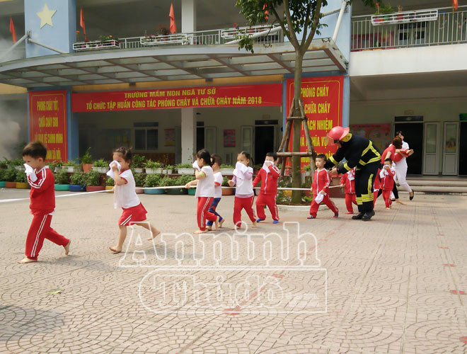 Để tránh xô đẩy, thất lạc trong lúc hỗn loạn, các em được hướng dẫn đi bám vào dây dưới sự hỗ trợ của cảnh sát PCCC và các cô giáo