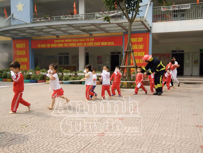 Để tránh xô đẩy, thất lạc trong lúc hỗn loạn, các em được hướng dẫn đi bám vào dây dưới sự hỗ trợ của cảnh sát PCCC và các cô giáo