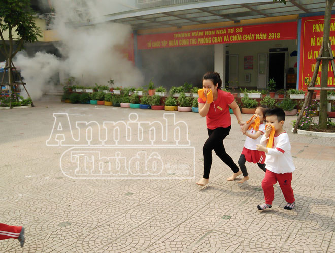 Một số em khác được giáo viên đưa ra nơi an toàn. Các em được trang bị khăn mặt ướt để chống khói độc.