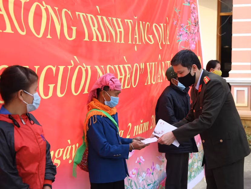 Thiếu tá Vũ Mạnh Hùng - Phó Tổng Biên tập Báo ANTĐ thay mặt Quỹ Thiện Tâm của Tập đoàn Vingroup trao từng suất quà đến tận tay bà con nghèo