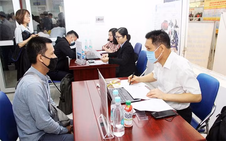 Người lao động trao đổi thông tin tại trung tâm dịch vụ việc làm Hà Nội