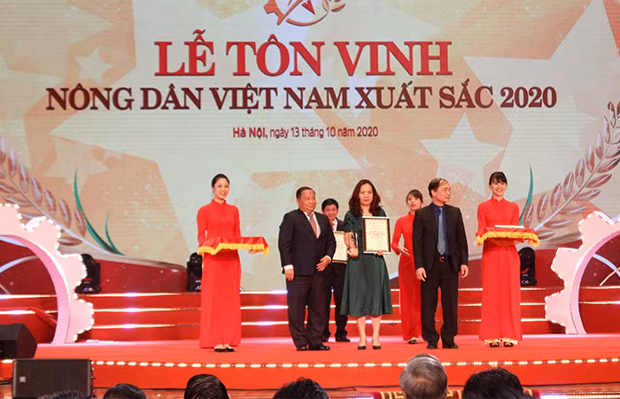 Đại diện FrieslandCampina (giữa, áo xanh) nhận danh hiệu doanh nghiệp tiêu biểu có đóng góp cho sự phát triển của kinh tế Nhà nước, nông nghiệp nông thôn