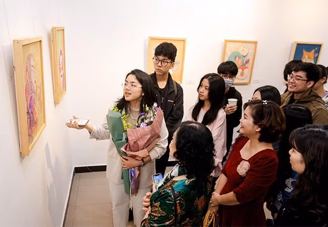 Nguyễn Nhật Mai giới thiệu với khách tham quan về các tác phẩm trưng bày tại triển lãm