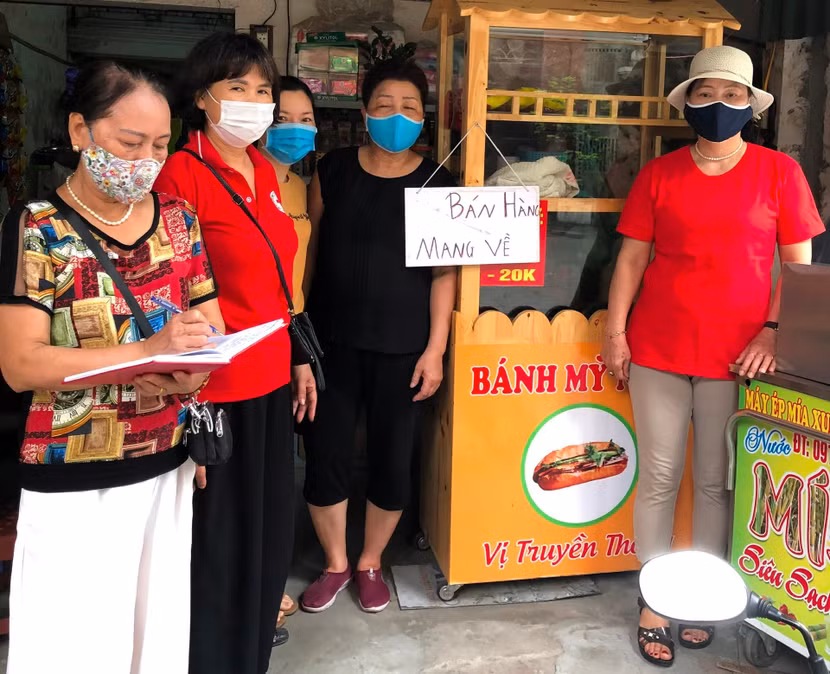 Cán bộ tổ dân phố 11 và 21 phường Tân Mai nhắc nhở người dân tuân thủ quy định phòng dịch Covid-19