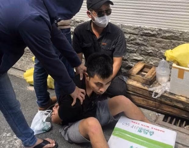 Đối tượng Ngô Quốc Hùng và tang vật là 8kg heroin ngụy trang trong thùng hàng quạt gió