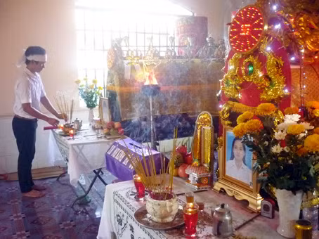  Em Sơn bên bàn thờ của chị và em trai.