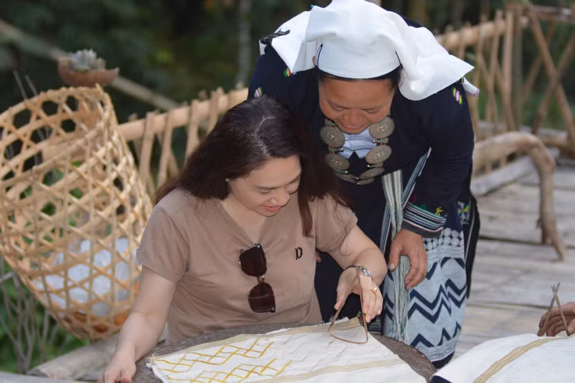 Du khách được trải nghiệm in sáp ong tạo hoa văn trên trang phục của người Dao Tiền