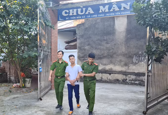 Hùng bị dẫn giải đến hiện trường. Ảnh: Công an cung cấp