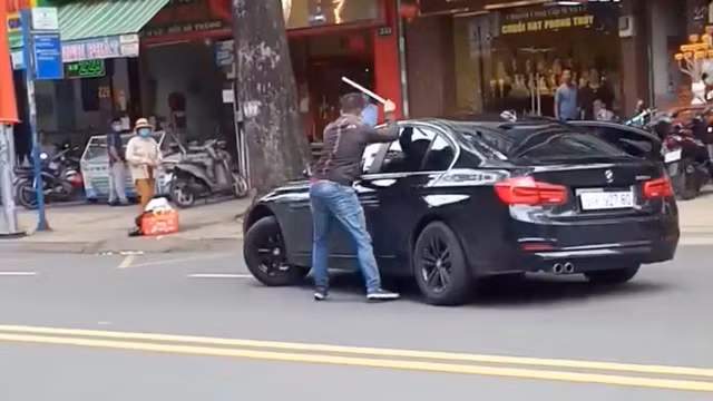 Nam thanh niên cầm gậy đập ô tô của người phụ nữ. Ảnh cắt từ clip Nam thanh niên cầm gậy đập ô tô của người phụ nữ. Ảnh cắt từ clip